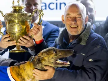 Proud owner poses with their winning greyhound at Dunstall Park greyhounds